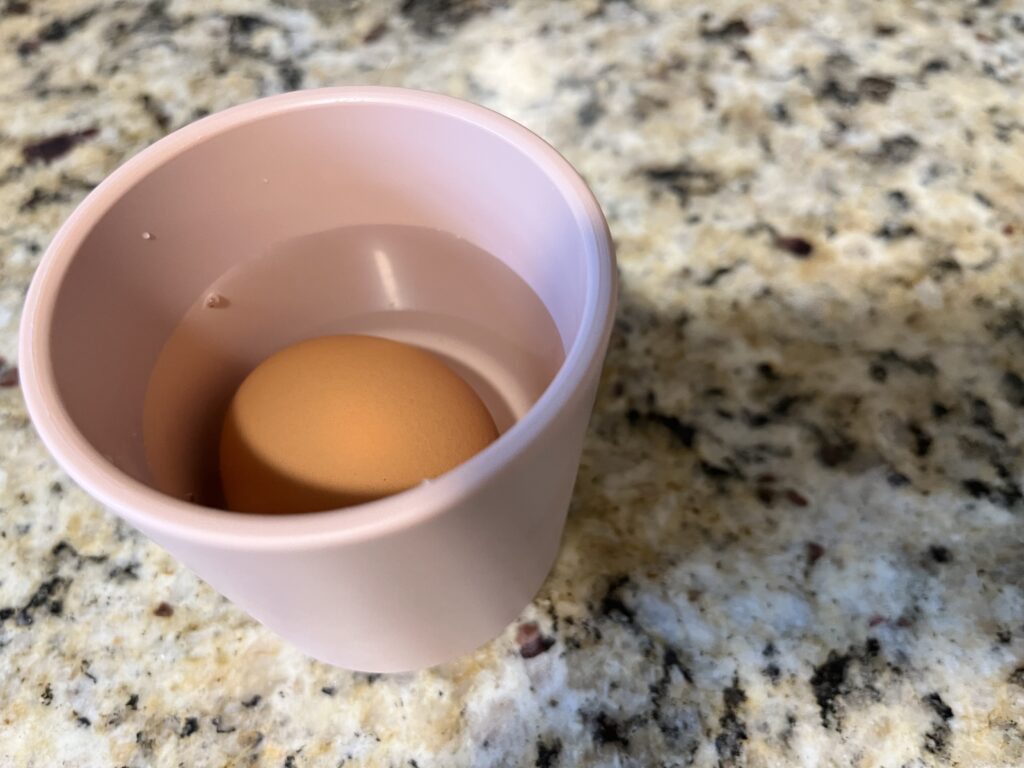お湯につかっている生卵を撮影した写真