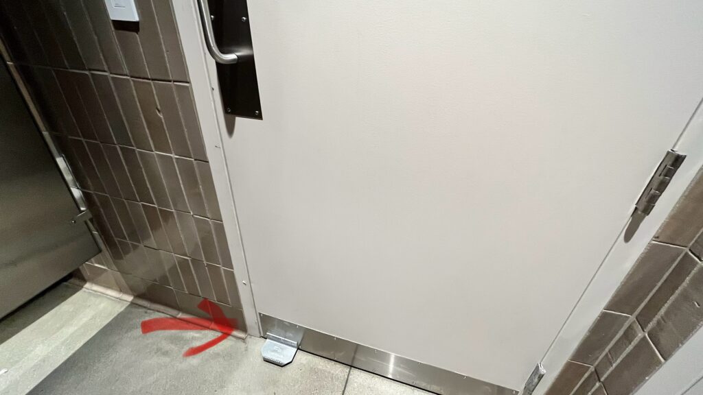 アメリカのトイレのドアの足を引っかけてドアを開ける仕掛けを撮影した写真。